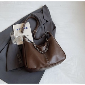 Close-up of brown PU leather hobo bag with thick gold metal chain and shoulder strap