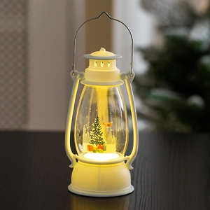 Close-up of white Christmas lantern with miniature tree and warm LED glowing effect