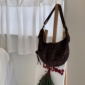 Detail of leopard print hobo bag with side drawstring knots and adjustable shoulder strap