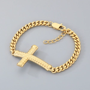 Détail du pendentif croix dorée en acier inoxydable et chaîne gourmette avec fermoir mousqueton