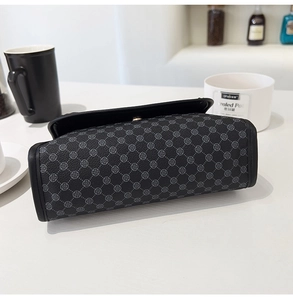 Détail du petit sac gris avec motif trèfle, texture en cuir et fermoir doré chic