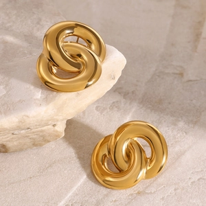 Minimalist double circle intertwined 18k gold earrings on a textured stone background