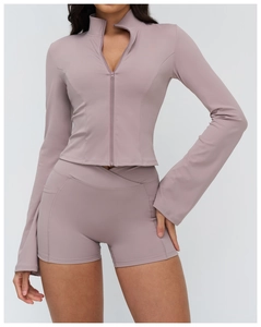 Detail of flared sleeves and high-waist shorts pockets on a purple yoga tracksuit