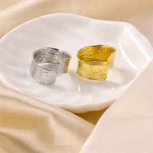 Detailed view of gold and silver hammered texture adjustable rings on white ceramic tray