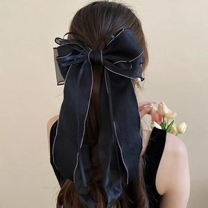 Elegant large black lace ribbon hair bow clip with long streamers on female model