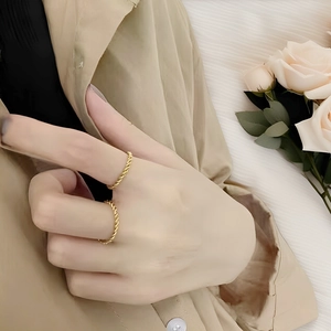 Close-up of dual stacked 18k gold-plated twisted rope rings on a finger