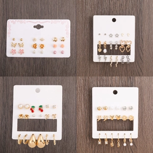 Set of 4 multi-style alloy earrings with gold and silver finishes on a wooden background