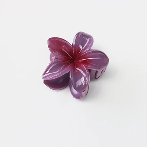 Close-up of a purple gradient frangipani hair claw clip made of glossy resin