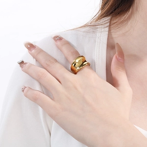 Detail of minimalist wide irregular wave ring with high-polish 18K gold finish