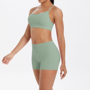 Vue latérale d'un ensemble de yoga vert sauge avec brassière à bretelles et short taille haute