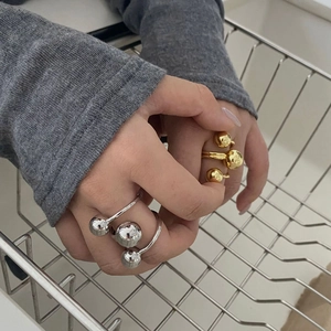 Three-layer brass gold plated ring with golden balls design on a model's hand