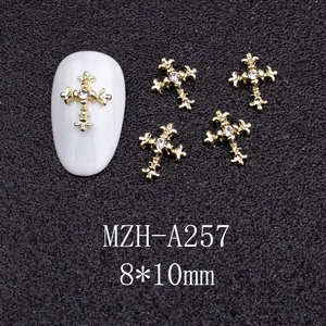 Macro view of 8x10mm gold cross nail art charms with crystal rhinestone inlay