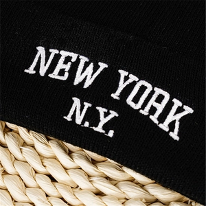Detail of New York embroidery on black knit beanie with fine fabric texture
