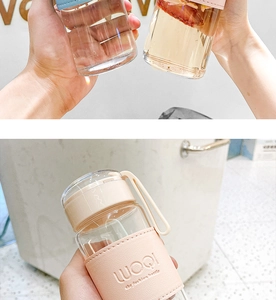 Detail of portable glass water bottle with pink leather sleeve and handle for insulation