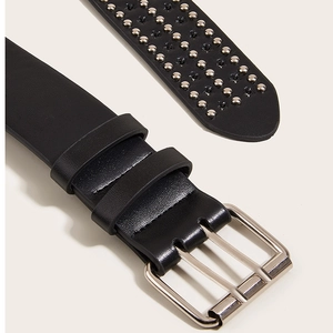 Détail de la ceinture punk en cuir noir avec rivets étoiles argentés et boucle double ardillon