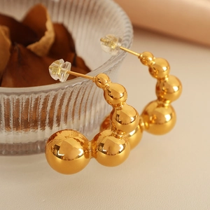 Polished gold pea-shaped beaded hoop earrings with gradient metal balls on glass rim