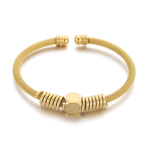 Golden mesh wire cable bangle with hexagonal charm and spring coils on white background