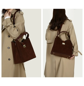Detail of vintage brown suede tote bag with golden twist lock and reinforced handles