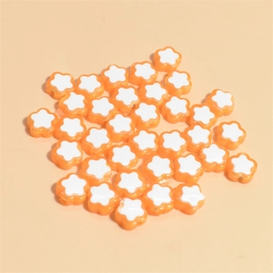 Macro view of 10mm orange and white flower resin beads for DIY jewelry making