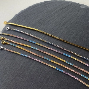 Detailed close-up of S925 silver tennis bracelets with colorful zircon stones on stone background