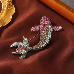 Elegant koi fish brooch with colorful rhinestones on a brown satin luxury background