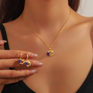 Elegant gold-plated celestial jewelry set featuring crescent moon and blue star pendants