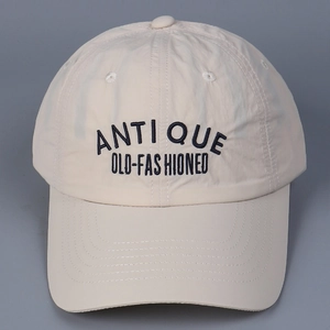Top view of beige quick-dry nylon baseball cap featuring black Antique embroidery detail
