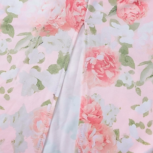 Detailed macro view of pink floral pattern and slit seam on a soft knit dress fabric