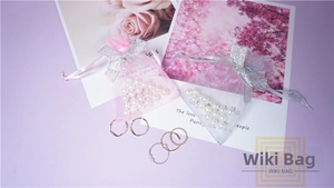 Detailed view of gray and pink organza gift bags with silver glitter bow drawstrings