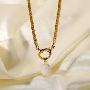 Macro shot of 18K gold plated snake chain with unique baroque pearl pendant