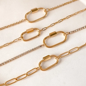 Détail de l'ensemble de chaînes en acier doré avec pendentifs coquillage et soleil