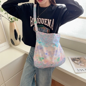 Macro shot of colorful floral print canvas tote bag styled with a casual black sweatshirt