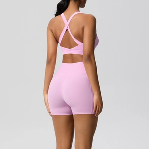 Detailed back view of pink yoga set featuring crisscross bra straps and high-waist shorts