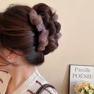 Elegant oversized plush bow claw clip in brown and purple for a stylish updo hairstyle