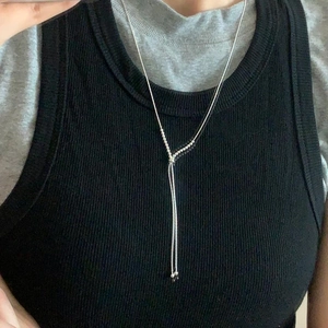Minimalist silver beaded Y-shaped chain necklace shown on a black ribbed sweater