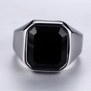 Anello alla moda con zircone quadrato nero e montatura in metallo argentato su sfondo grigio