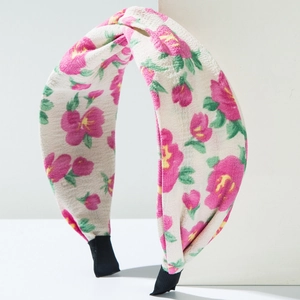 Détail du serre-tête fleuri en tissu froissé crème avec des motifs de fleurs roses