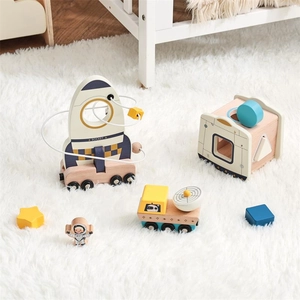 Close-up of space-themed wooden stacking rocket and moon rover toys on soft white rug