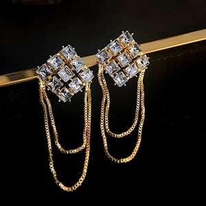 Macro view of gold tassel earrings with square cubic zirconia and long chain detail