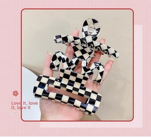 Detail of three black and white checkered hair claws in various vintage patterns