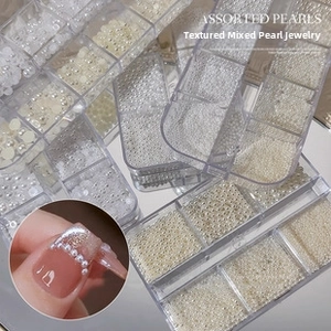 Detail of assorted white nail art pearls in a clear 6-grid organizer storage box