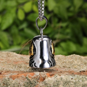 Retro stainless steel skull bell pendant necklace on rock with natural green background