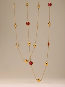 Détail du collier plaqué or 18 carats avec pierres en verre facetté rouges et transparentes