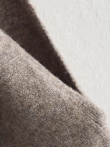 Close-up of melange brown knit fabric texture with coarse knit stitch details