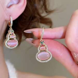 Detail of 14k gold-plated gourd earrings with pink cat-eye stones and pavé zircons