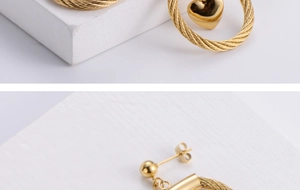 Detailed close-up of gold heart pendant earrings with twisted rope texture design
