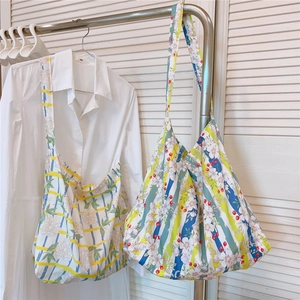 Detailed view of floral cotton tote bags with striped patterns hanging on a rack