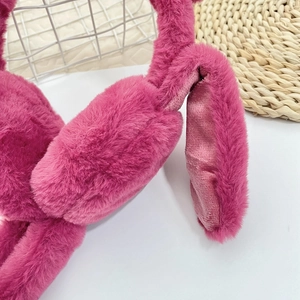 Nahaufnahme des weichen erdbeerrosa Plüschstoffs und der flauschigen Ohren von Ohrenschützern