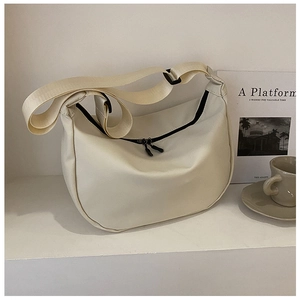 Detailed macro shot of the cream nylon crescent bag with double zipper and wide strap