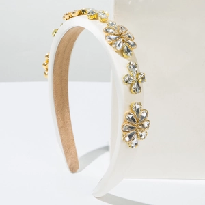 Vue détaillée du serre-tête baroque avec fleurs en cristal sur satin blanc rembourré